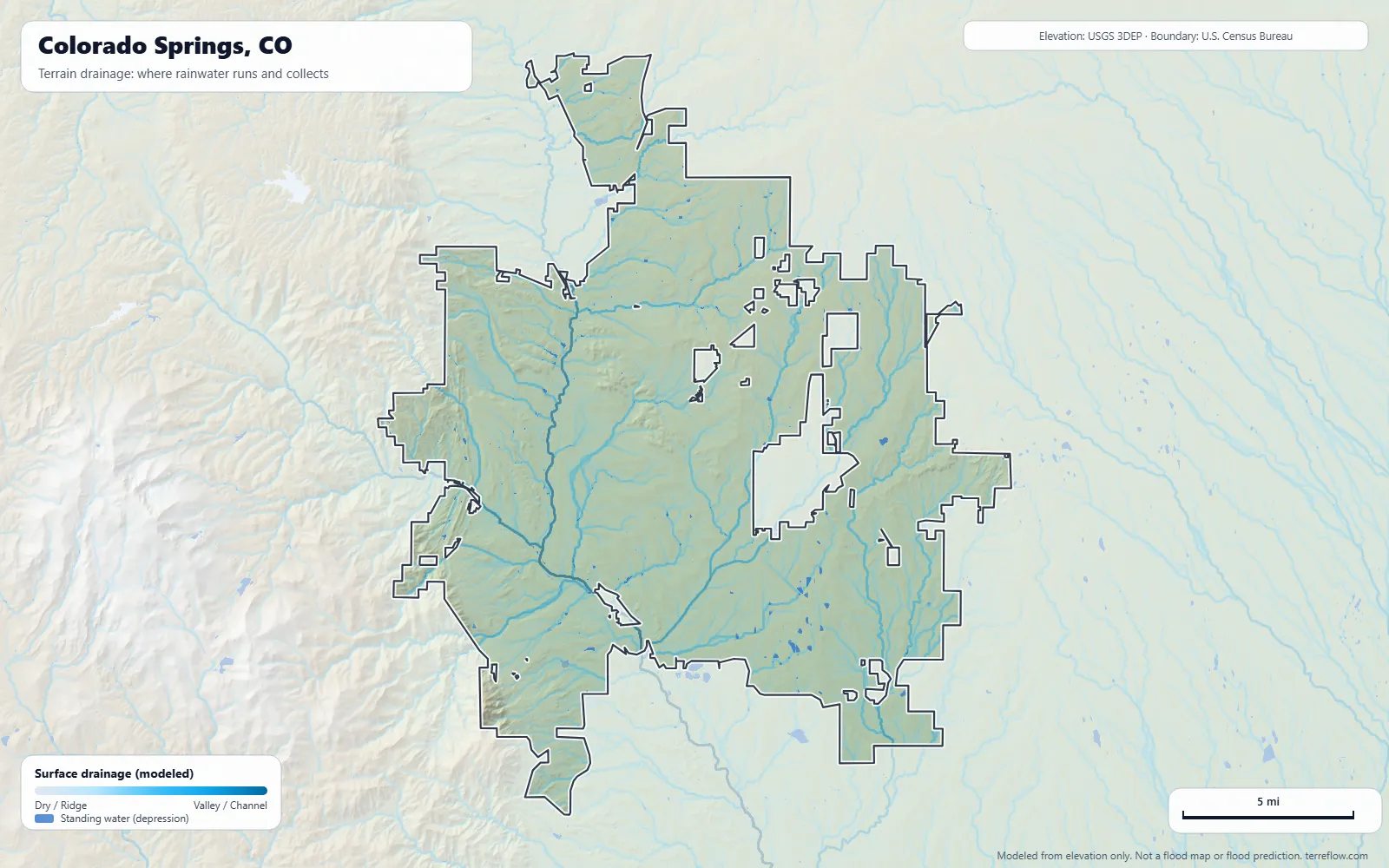 Terrain drainage map of Colorado Springs, CO: modeled paths where rainwater runs and collects, from USGS 3DEP elevation data, with the city boundary